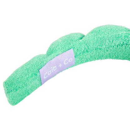 inside of a green spa headband with "cait + co" tag against a white background