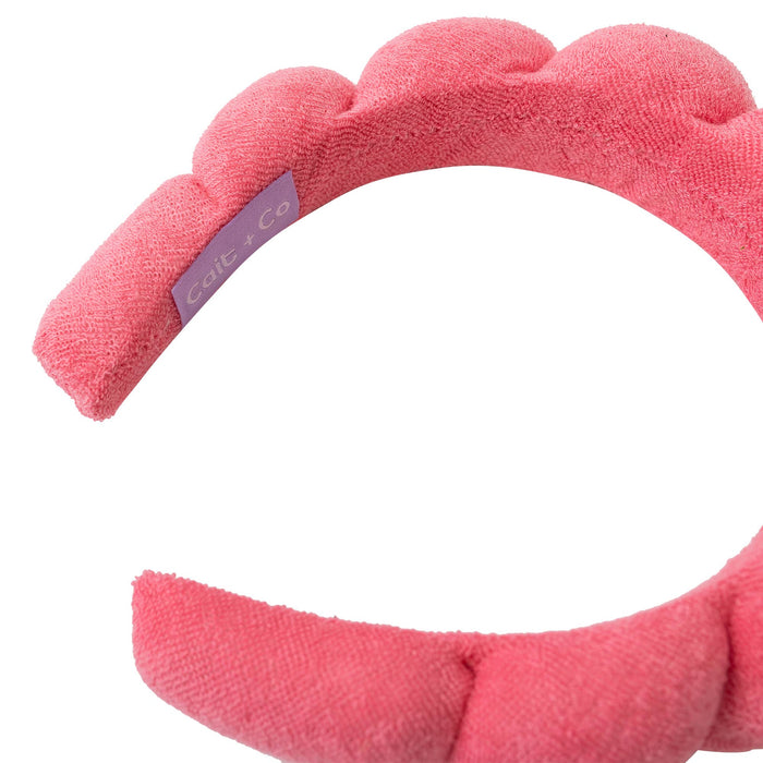 inside of a pink spa plush headband with "cait + co" tag against a white background