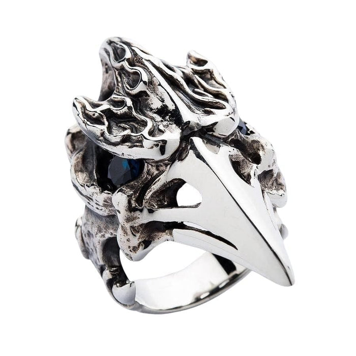A close-up macro shot of the piercing blue topaz gemstone eye in the raven skull ring.