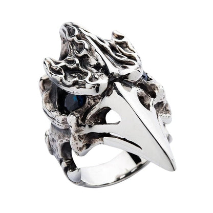 A close-up macro shot of the piercing blue topaz gemstone eye in the raven skull ring.