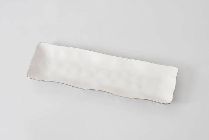 Silver lined white ceramic serving tray 
on a light gray background