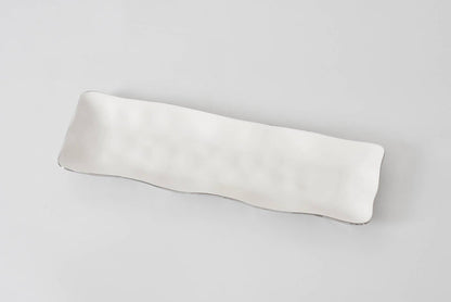 Silver lined white ceramic serving tray 
on a light gray background