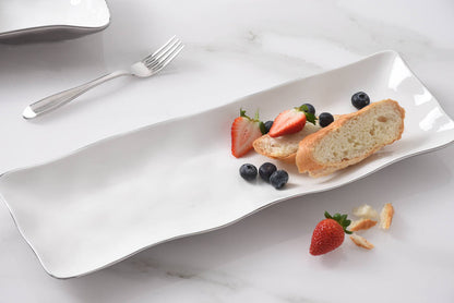 Rectangular white plate with bread and berries on a marble surface