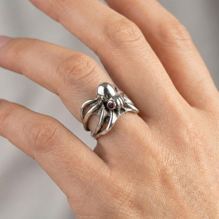 Handcrafted sterling silver octopus ring worn on finger demonstrating adjustable fit
