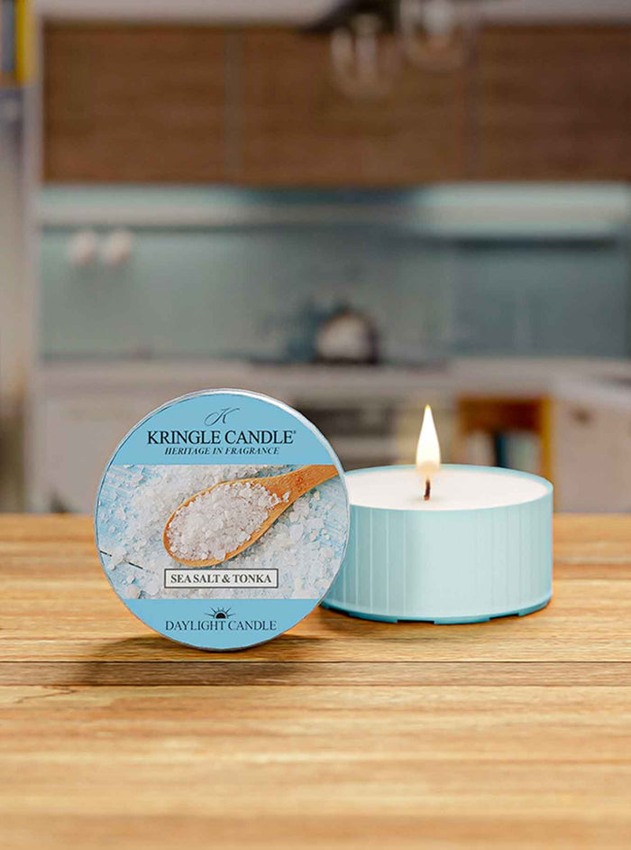 Kingle Candle with a lit candle on a wooden surface in a kitchen setting