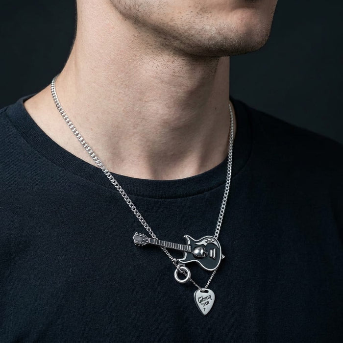 Male model wearing the .925 sterling silver skull guitar pendant on a polished silver curb chain — guitar lies horizontally with the Gibson USA pick charm hanging straight down from the bail.
