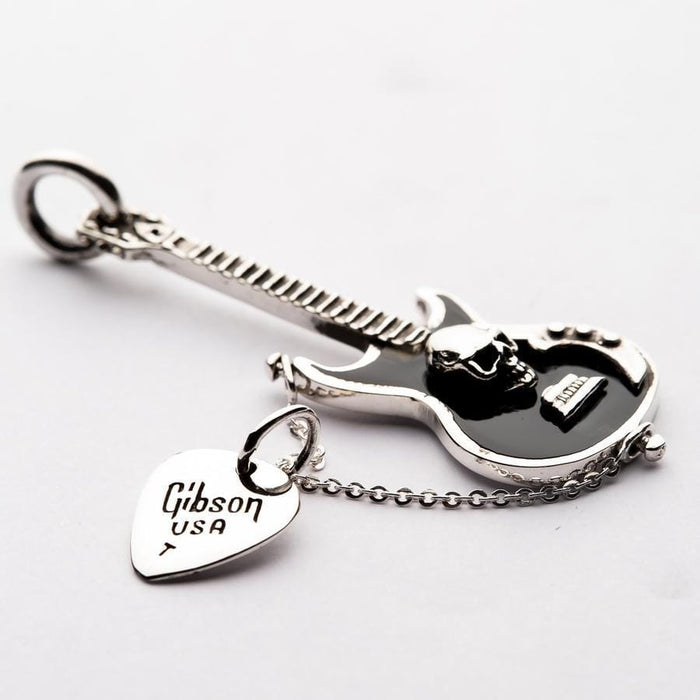 Angled detail of the black enamel guitar body featuring a 3D silver skull and attached Gibson USA engraved pick charm.