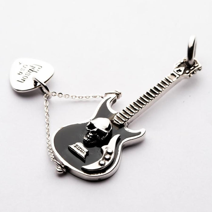 A detailed shot of the skull emblem and black enamel on the sterling silver guitar pendant.