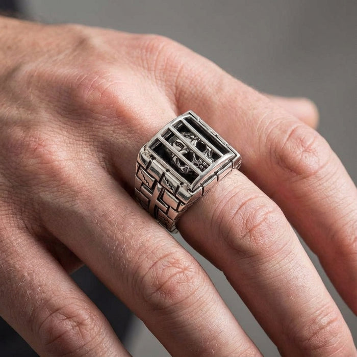 A model's hand wearing the massive and detailed sterling silver prisoner skull ring to demonstrate its impressive and bold style.