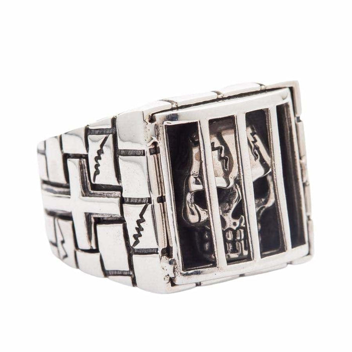 A unique sterling silver prison ring with a skull held captive inside, a powerful symbol of an unbreakable spirit.