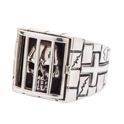 A premium piece of authentic biker jewelry: a heavy sterling silver ring of a skull trapped in a cage.