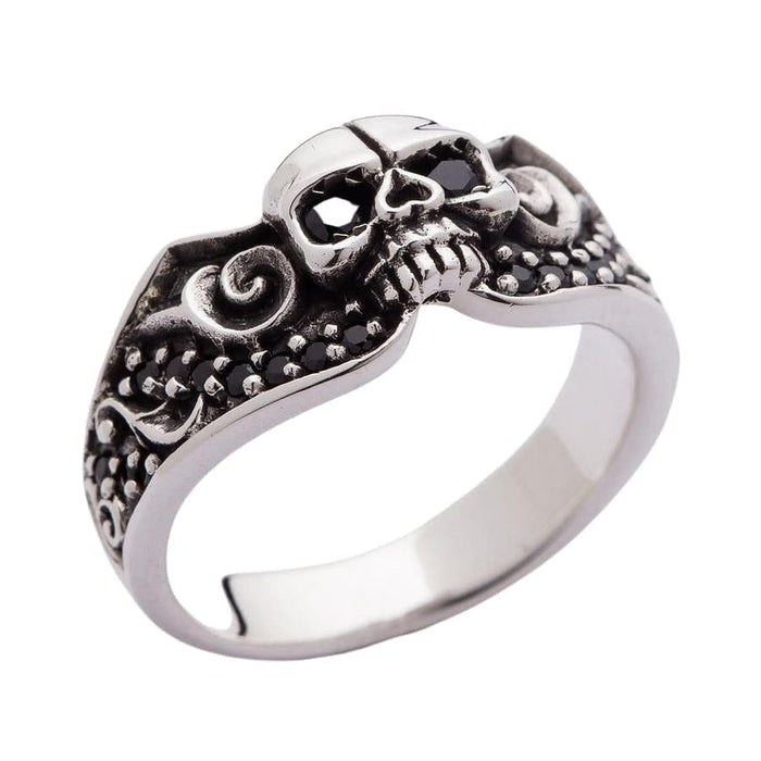 An angled view of a black jeweled skull wedding ring with intricate tribal gothic swirls, handcrafted from solid sterling silver.