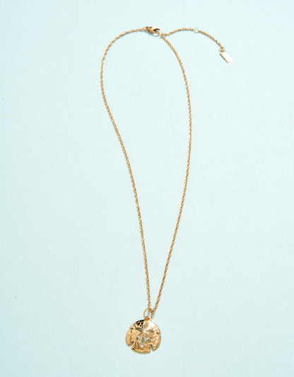 Gold necklace with a pendant on a light blue background