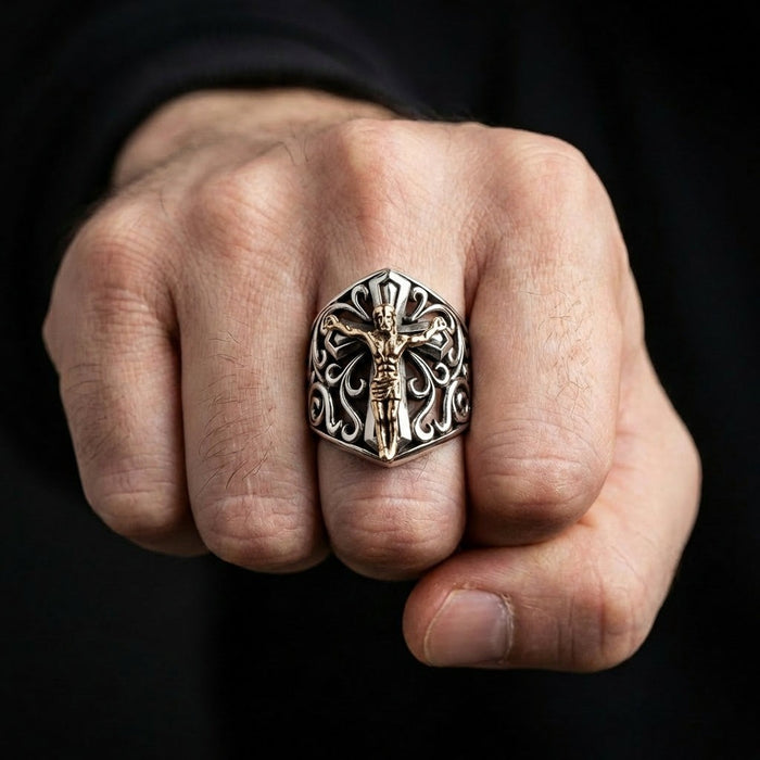 Man wearing handmade 925 sterling silver crucifix ring with bronze Jesus figure shown on clenched fist against black background