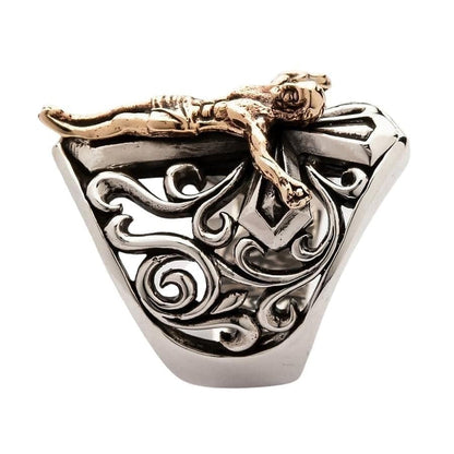 Top down view of sterling silver crucifix ring displaying bronze Christ figure and baroque silver scroll openwork