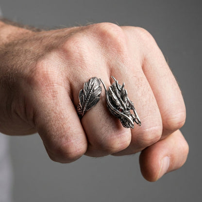 Man wearing silver dragon ring on middle finger showing dragon head and tail wrap-around design