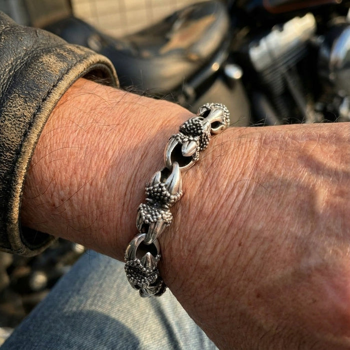 Biker style sterling silver eagle claw bracelet on wrist with leather jacket and motorcycle