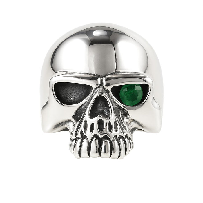 A front-on studio shot of the green eye skull ring, showing the high-polish cranium.