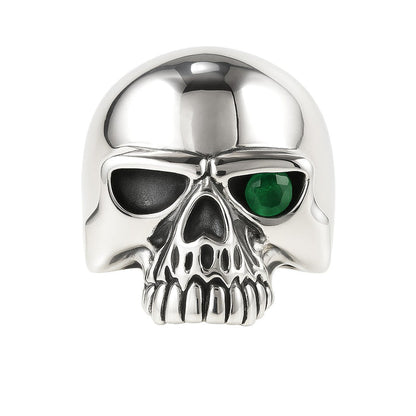 A front-on studio shot of the green eye skull ring, showing the high-polish cranium.
