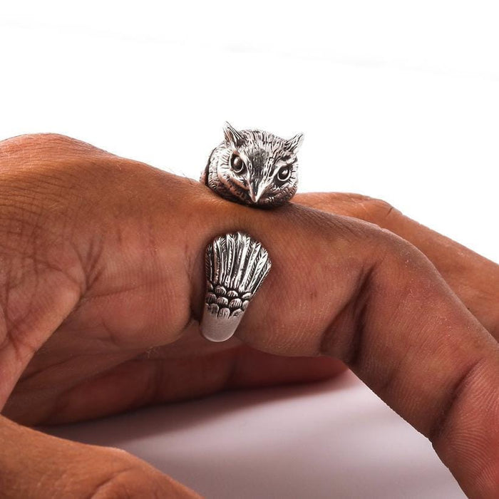 A man's hand wearing the gothic owl wrap ring, showing its bold style on the finger.