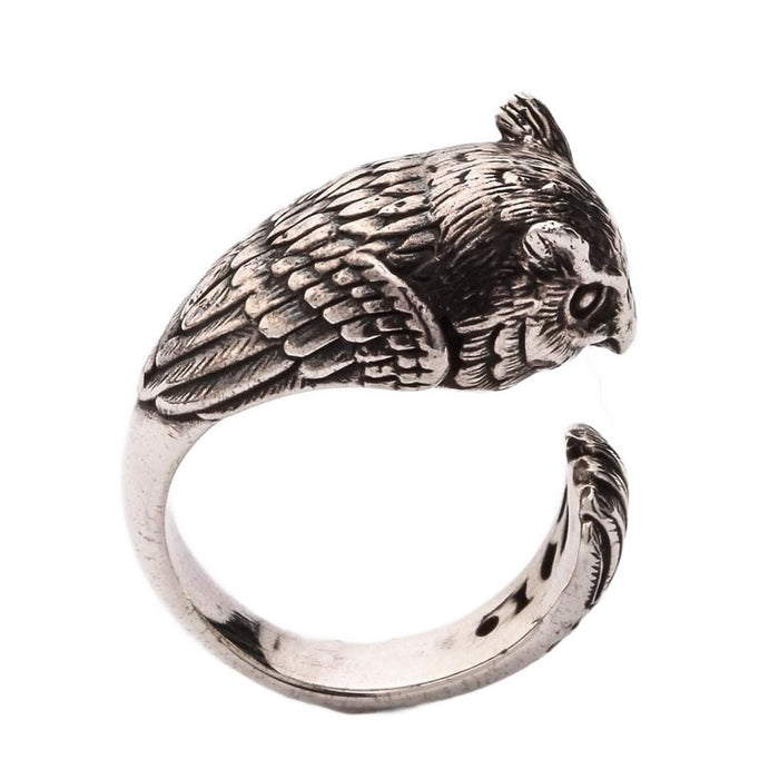 A close-up macro shot of the detailed and oxidized feather texture on the silver owl wrap ring.