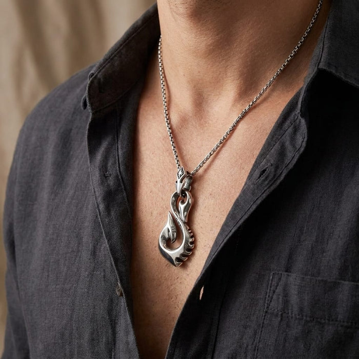 Male model wearing a silver tribal fishhook pendant necklace with a dark shirt.