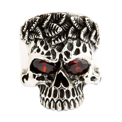 A heavy and solid sterling silver tribal skull ring, featuring intricate carvings and two fiery, brilliant red CZ eyes.