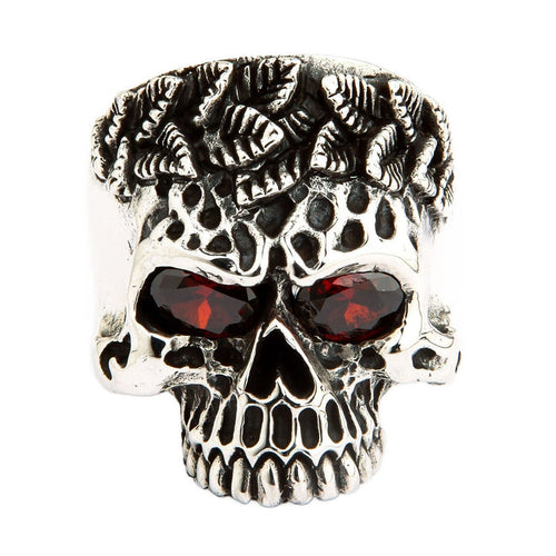 A heavy and solid sterling silver tribal skull ring, featuring intricate carvings and two fiery, brilliant red CZ eyes.