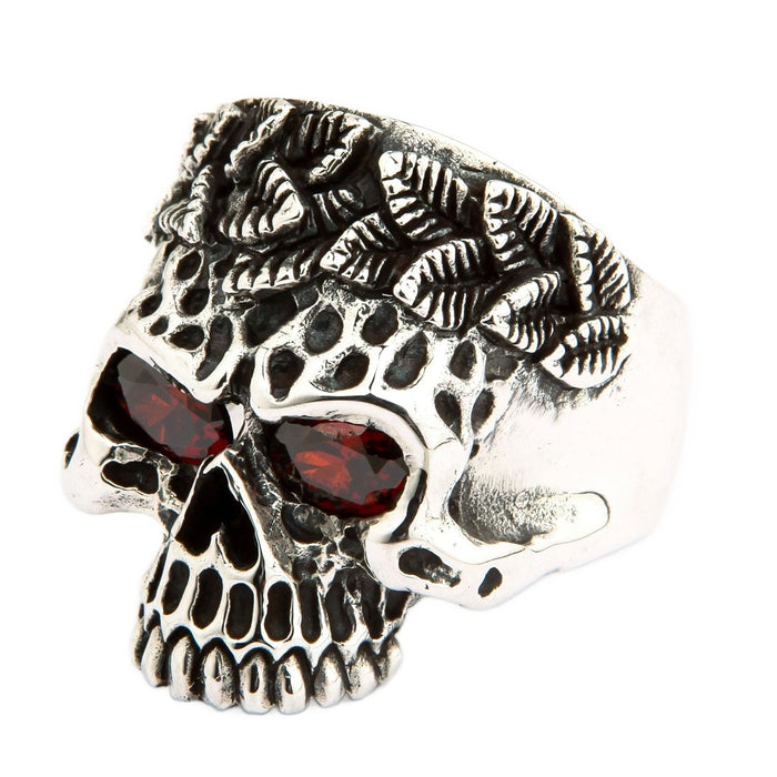 A beautifully handcrafted sterling silver tribal ring with a detailed skull motif and brilliant, deep red stone eyes.