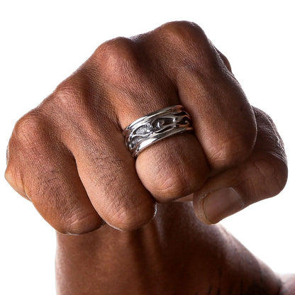 A man's fist showing the wide tribal band ring on his finger against a white background.