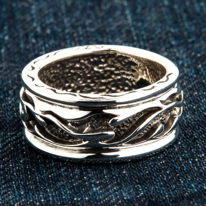 A side-angled view of the men's tribal silver band ring, 11mm wide, on a denim background.