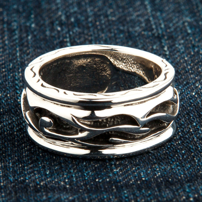 An angled view of the sterling silver tribal ring showing the continuous carved wave and flame pattern.