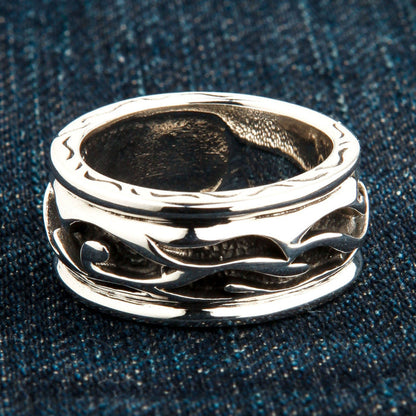 An angled view of the sterling silver tribal ring showing the continuous carved wave and flame pattern.
