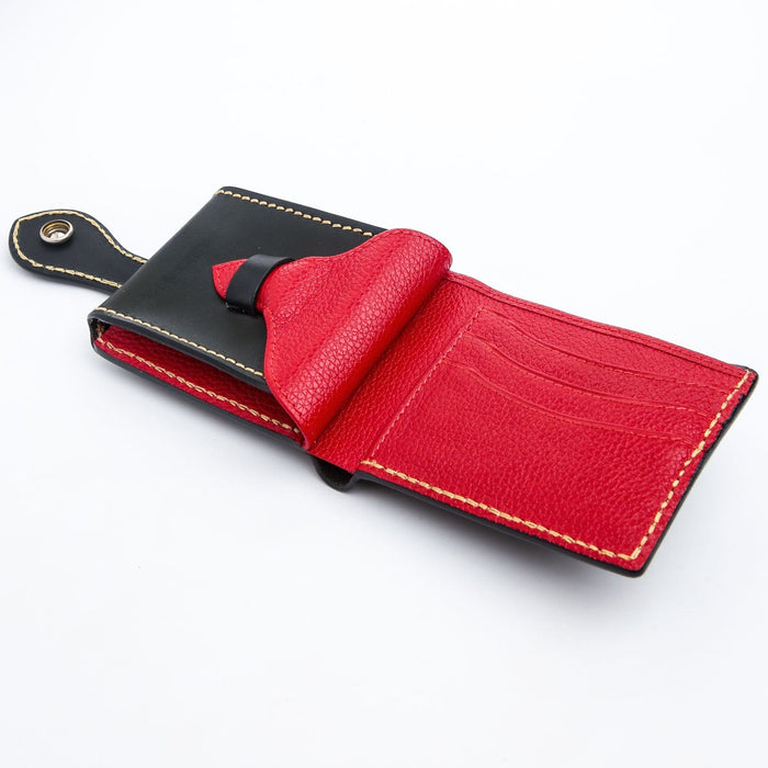 A beautifully hand-carved leather wallet with a striking red interior and a custom turquoise snap closure.