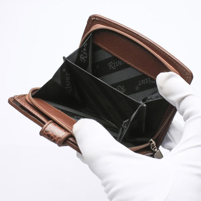 Detailed shot of secure zipper coin compartments on brown crocodile wallet