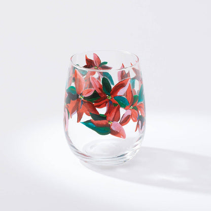 A stemless wine glass with a printed artwork of poinsettia leaves on a white background.