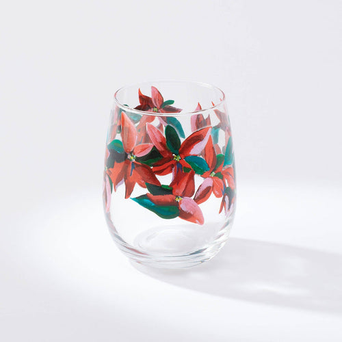 A stemless wine glass with a printed artwork of poinsettia leaves on a white background.