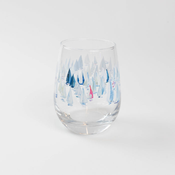 A stemless wine glass with a clear glass body and blue patterned artwork featuring boats.