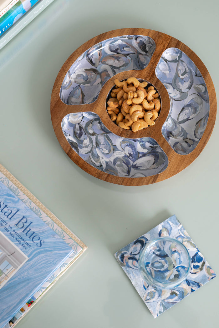 Wooden snack tray with oyster pattern, holding cashews on table